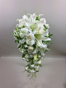純白のウェディングドレスには、ゴージャスなユリをメインに可愛らしいお花をプラスしたキャスケードブーケはいかがですか？