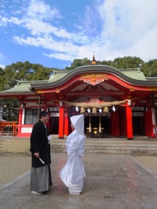 挙式後に青空のもとで微笑む2人